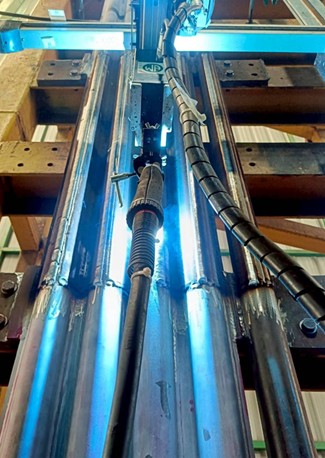 A close-up of a cladding machine in operation in the new facility.